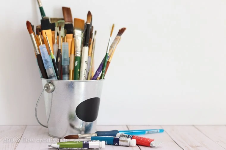 watercolor brushes in tin bucket