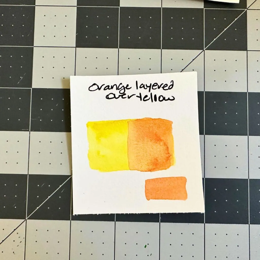 layering orange watercolor over yellow