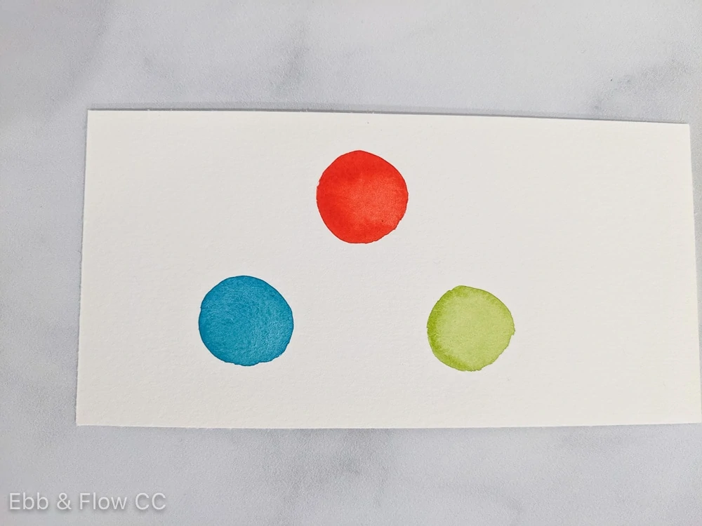 watercolor swatches of red, blue green and yellow green on paper