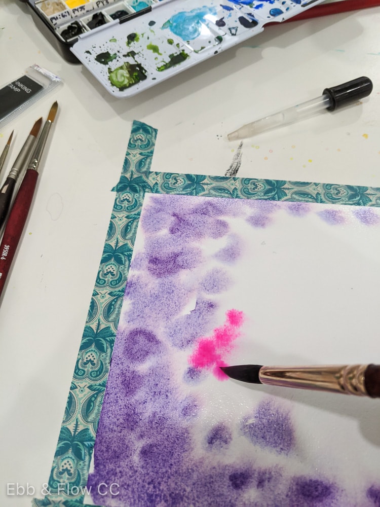 adding dots of pink to the purple paint