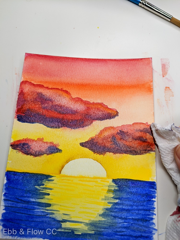 blotting away paint with paper towel