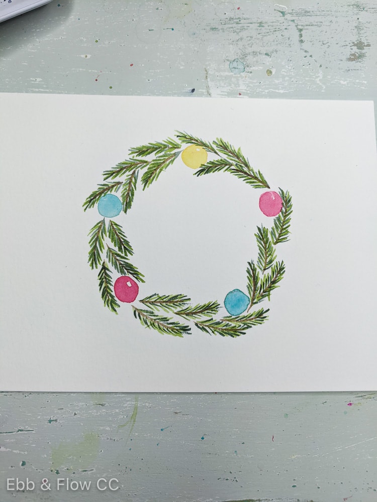 adding darker green pine leaves to painted wreath