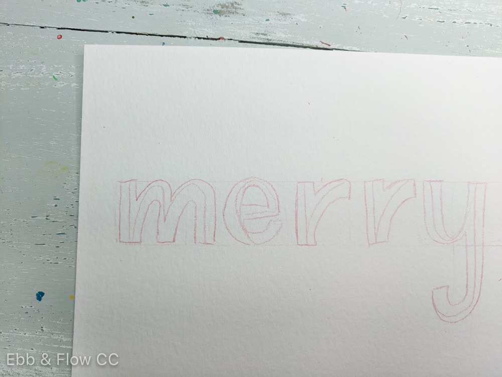 drawing block lettering that says "merry"