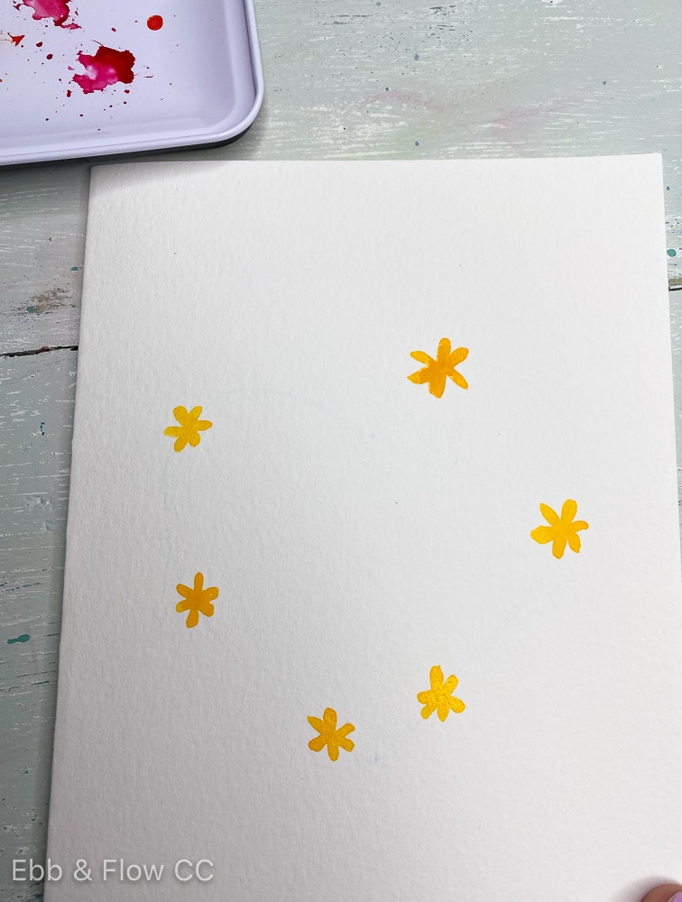 adding yellow flowers to heart shape with paint