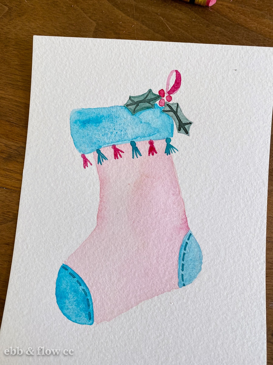watercolor painting of stocking with holly leaves