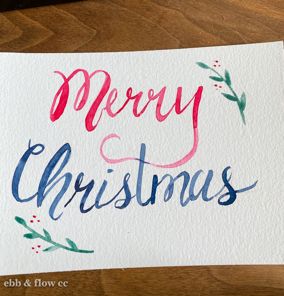watercolor card that says "Merry Christmas" in cursive