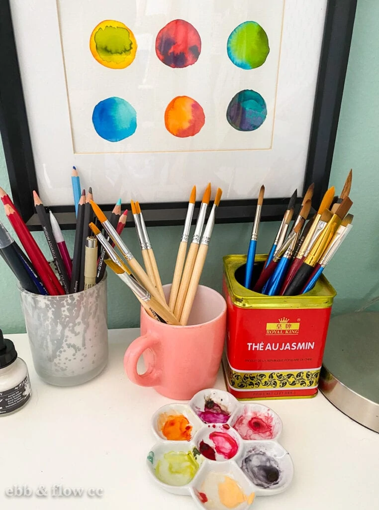 brushes stored in cups on desk