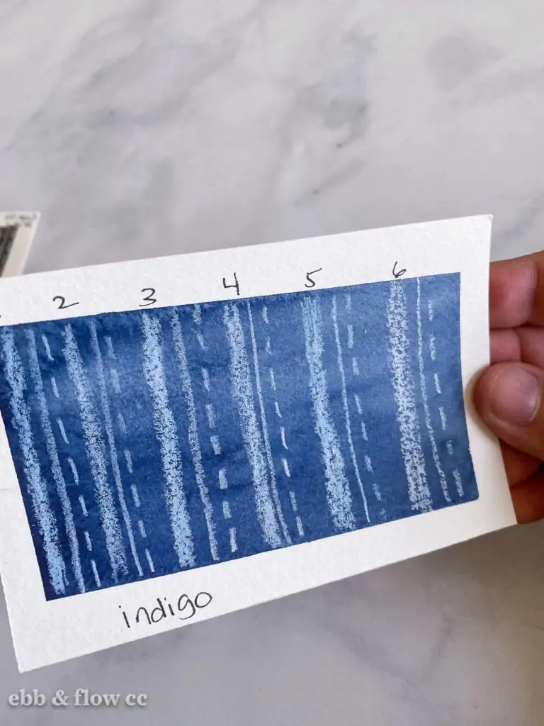 indigo watercolor swatch with white pencil marks