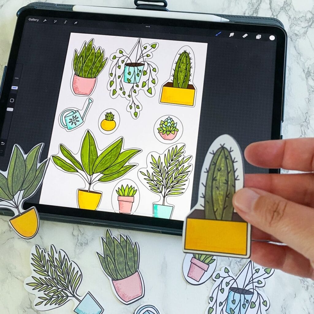 ipad with plant art and hand holding cactus sticker