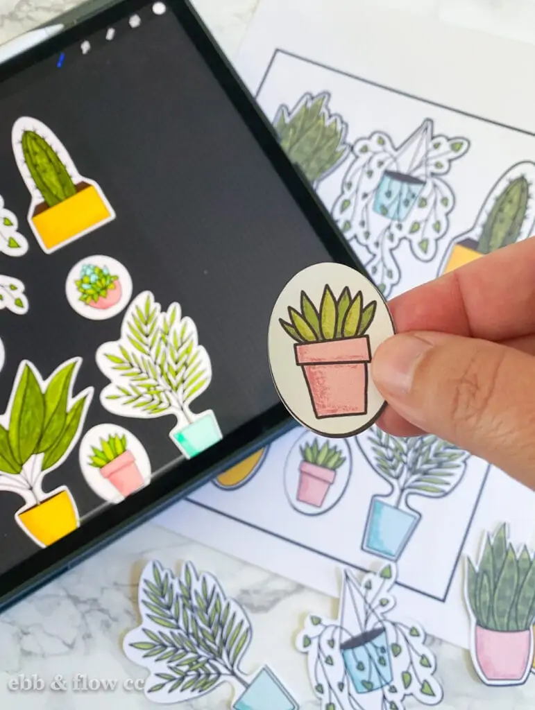 hand holding plant sticker with iPad in background