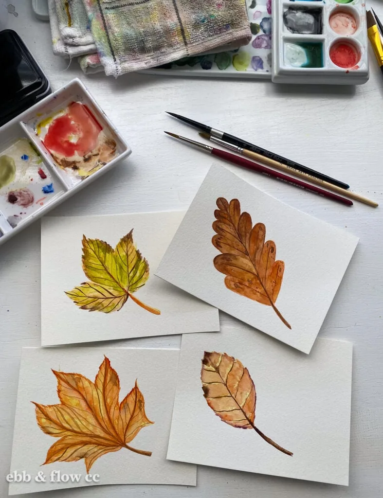 fall leaves painted with watercolor, brushes, and mixing palette