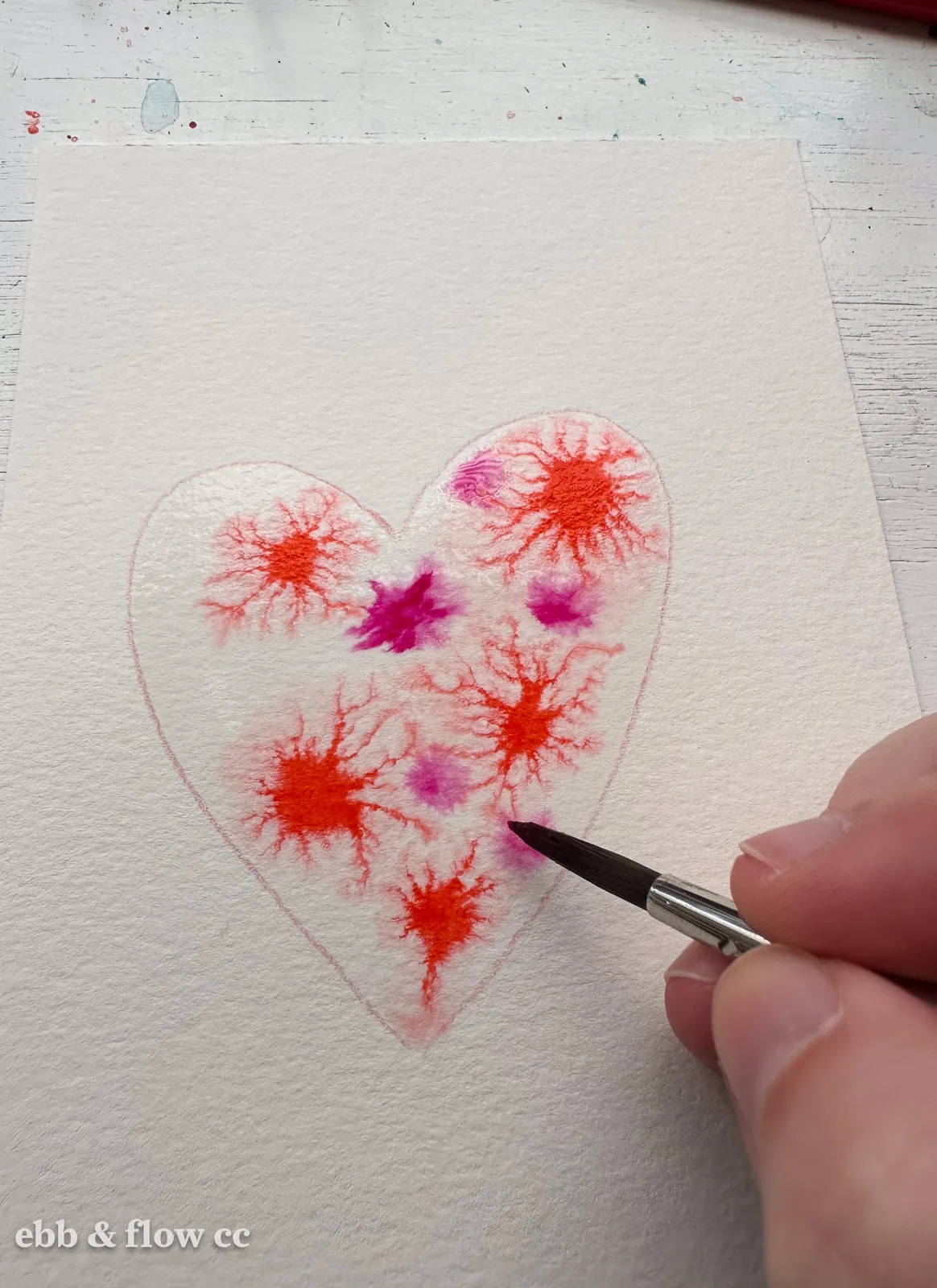 paint colors added to water heart shape on paper