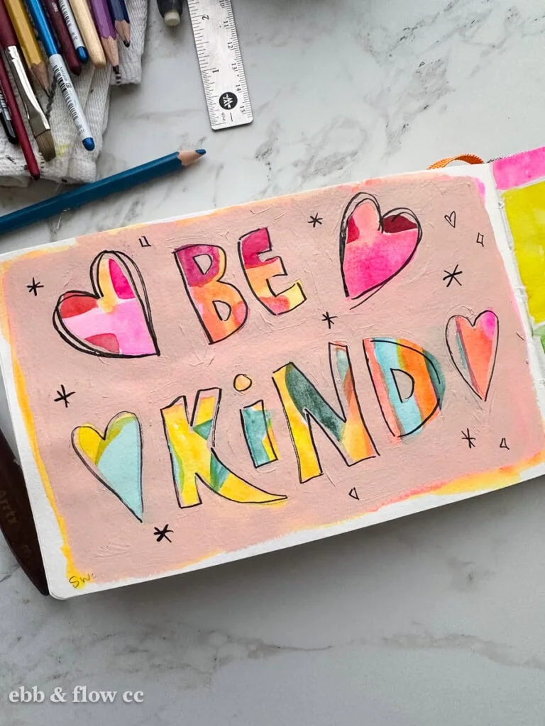 acrylic paint over watercolor paint spelling out "Be Kind" with hearts
